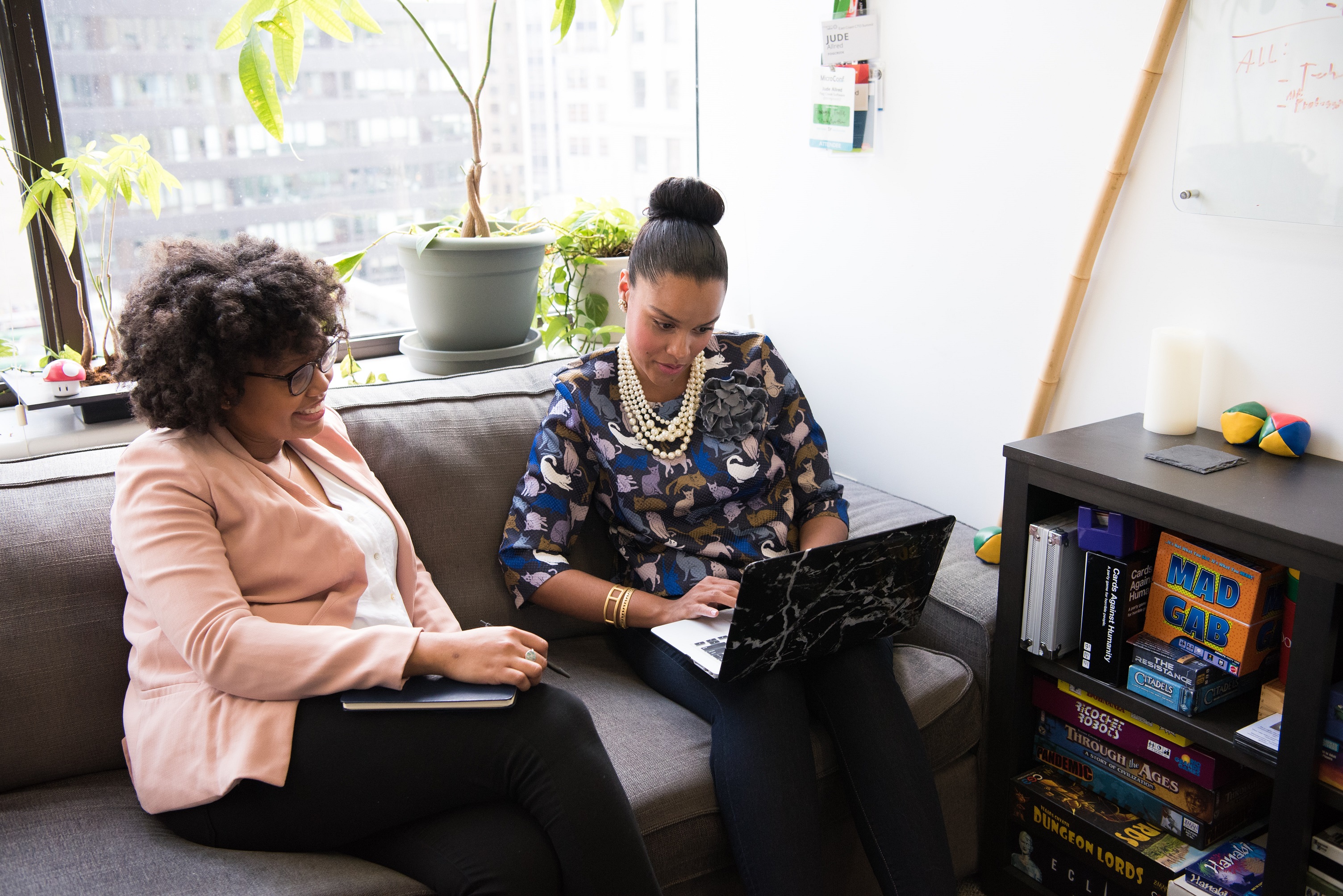 Two women looking at laptops in an office