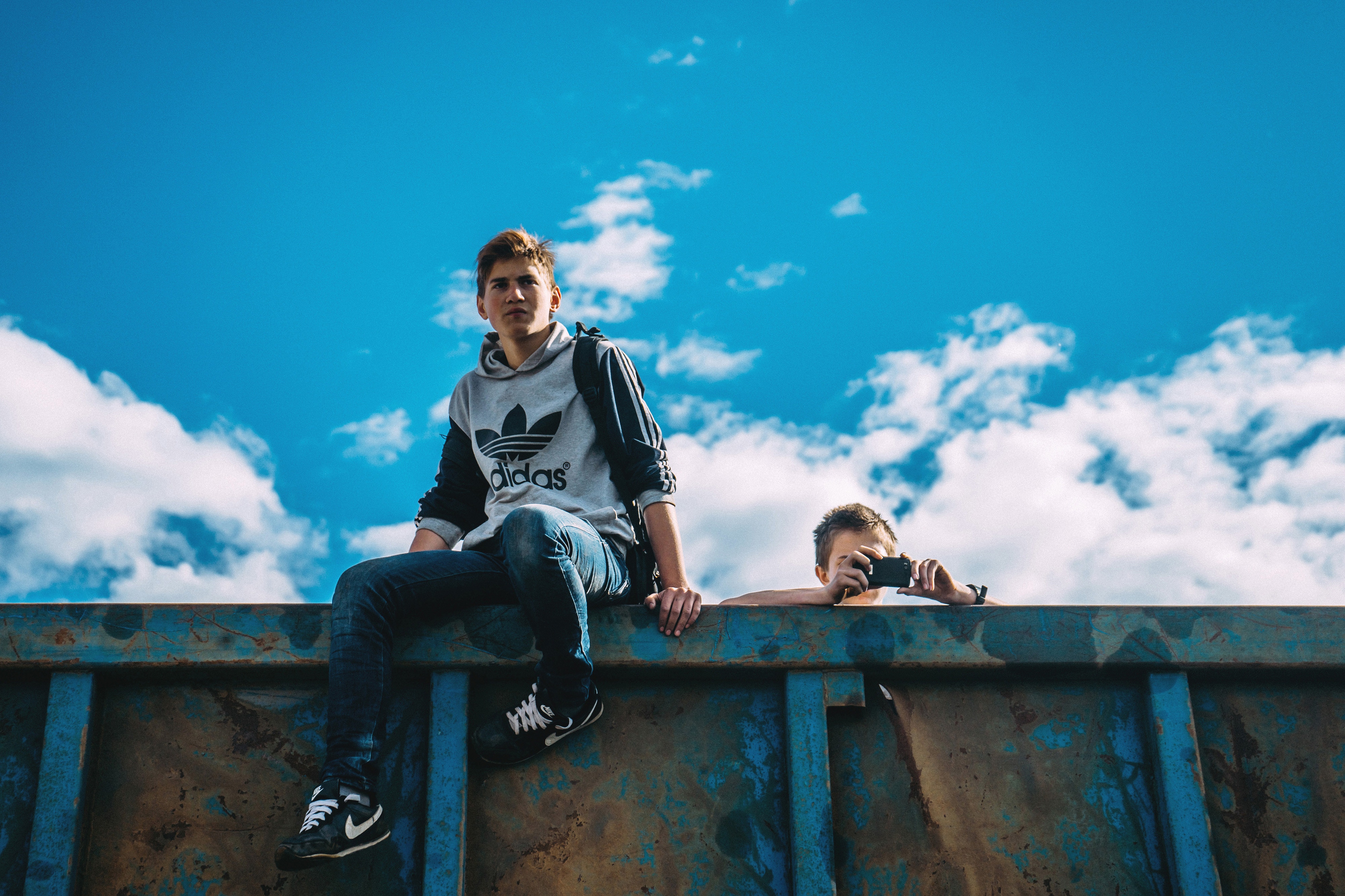 Two young teenagers sitting on a shipping container